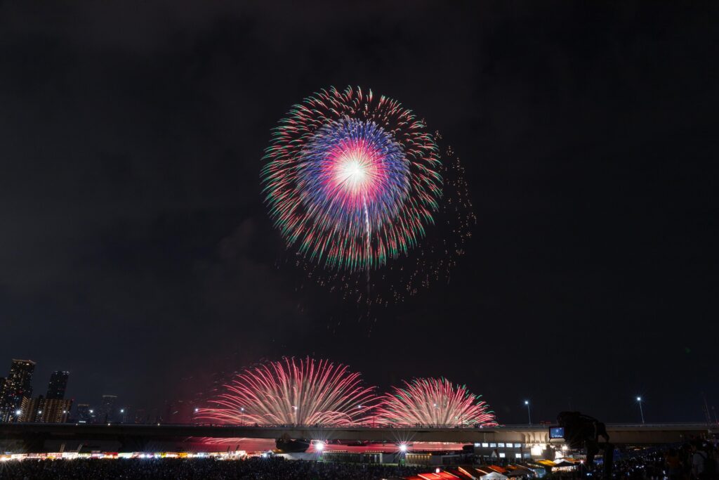 Vibrant fireworks illuminate the night sky in a stunning urban celebration.