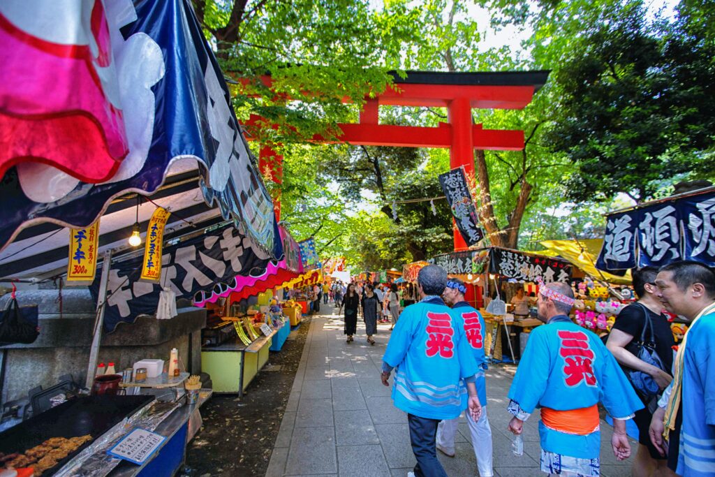 Lively scene at a traditional Japanese street festival in Tokyo with colorful stalls and visitors.